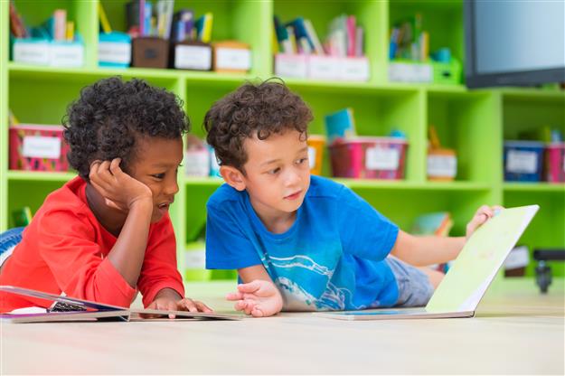 two boys reading a book